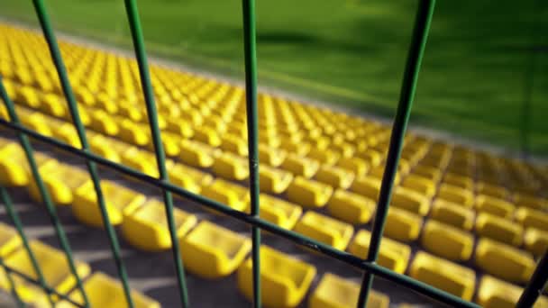スタジアムは鉄の柵で囲まれている 観客もファンもいないスタジアムの空の席 コロナウイルスのパンデミックによる試合のキャンセル アクセスは終了 — ストック動画