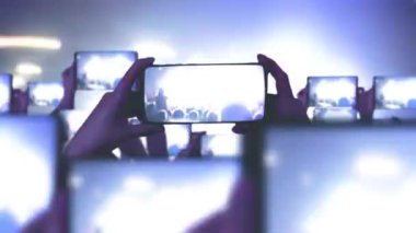 Kalabalık bir konser izliyor, şarkı söylüyor, zıplıyor. Konser sırasında havada yüzen altın konfetileri. Hayranlar akıllı telefonlardan video kaydediyor. Bir sürü akıllı telefon. Canlı yayın. Hikayeler. Sahne ışığı.