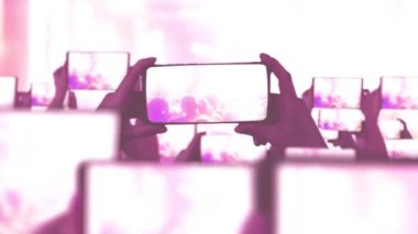 Kalabalık bir konser izliyor, şarkı söylüyor, zıplıyor. Konser sırasında havada yüzen altın konfetileri. Hayranlar akıllı telefonlardan video kaydediyor. Bir sürü akıllı telefon. Canlı yayın. Hikayeler. Sahne ışığı.