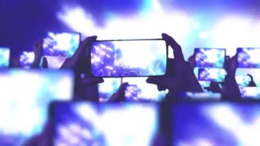 Kalabalık bir konser izliyor, şarkı söylüyor, zıplıyor. Konser sırasında havada yüzen altın konfetileri. Hayranlar akıllı telefonlardan video kaydediyor. Bir sürü akıllı telefon. Canlı yayın. Hikayeler. Sahne ışığı.