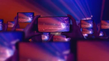 Kalabalık bir konser izliyor, şarkı söylüyor, zıplıyor. Çarpıcı sahne ışıkları. Mutlu insanlar. Müzik konsepti. Hayranlar akıllı telefonlardan video kaydediyor. Bir sürü akıllı telefon. Canlı yayın. Hikayeler.