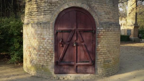 Château d'eau en brique contre ciel bleu. Ancienne tour ronde avec porte en bois sur serrure. Tour dans la vigne. Conte de l'emprisonnement de la princesse. Lieu mystique . 