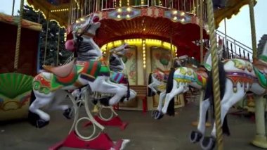 Ukrayna, Kyiv, 15 Şubat 2020. Bir sürü ışığı olan atlı karınca lunaparkta dönüyor. Atlıkarınca. Atlı karınca boyalı atlar. Noel zamanı. Yeni yıl. Baş dönmesi, baş dönmesi. Çocukluk. 