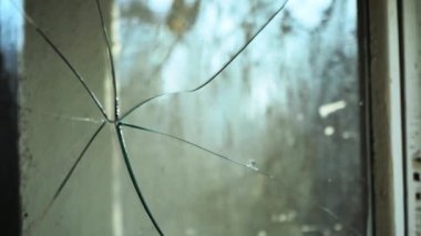 Eski kırık pencere. Camda kırık cam var. Kırık bir pencereden güneş ışığı. Bardaktan yağmur damlaları akıyor. Sisli pencere, yakın plan. Terk edilmiş bir ev. Vandalizm.