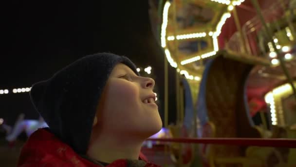 Bir Çocuk Akşamları Yanan Atlıkarıncaya Bakıyor Çocuk Lunaparktaki Dönen Atlıkarıncanın — Stok video