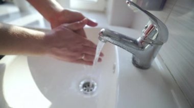 Ellerini sabunla yıkayarak koronavirüs salgınını önlemek. Adam musluğun altında ellerini sabunla yıkıyor. Antibakteriyel jelle tam bir el yıkama. Sağlık, vücut bakımı. Virüs koruması.