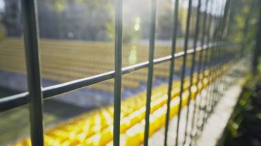 Stadyum demir bir çitle çevrili. Stadyumda seyirciler ve taraftarlar olmadan boş koltuklar. Koronavirüs salgını yüzünden eşleşmelerin iptal edilmesi, karantina. Erişim kapalı. Dünya Kupası ve Avrupa Futbol Şampiyonası iptal edildi.