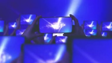 Kalabalık bir konser izliyor, şarkı söylüyor, zıplıyor. Altın konfeti. Hayranlar akıllı telefonlardan video kaydediyor. Bir sürü akıllı telefon. Canlı yayın. Hikayeler. Mutlu insanlar inanılmaz bir konser izliyorlar.