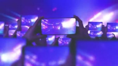 Kalabalık bir konser izliyor, şarkı söylüyor, zıplıyor. Altın konfeti. Hayranlar akıllı telefonlardan video kaydediyor. Bir sürü akıllı telefon. Canlı yayın. Hikayeler. Mutlu insanlar inanılmaz bir konser izliyorlar.