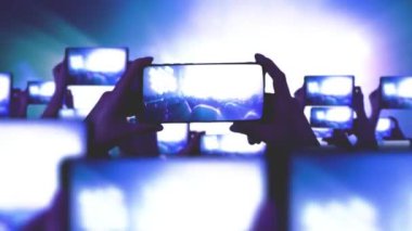 Kalabalık bir konser izliyor, şarkı söylüyor, zıplıyor. Altın konfeti. Hayranlar akıllı telefonlardan video kaydediyor. Bir sürü akıllı telefon. Canlı yayın. Hikayeler. Mutlu insanlar inanılmaz bir konser izliyorlar.