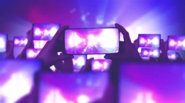 Konserdeki mutlu insanlar. Bir sürü akıllı telefon. Hayranlar akıllı telefonlardan video kaydediyor. Müzik konsepti. Canlı yayın. Hikayeler. Kalabalık bir konser izliyor, şarkı söylüyor, zıplıyor. Çarpıcı sahne ışıkları. 