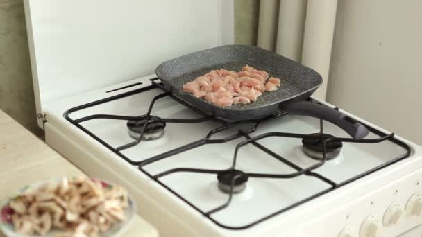 Friggere la carne sui fornelli in cucina — Video Stock