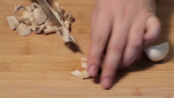 Різання грибів ножем на кухні — стокове відео