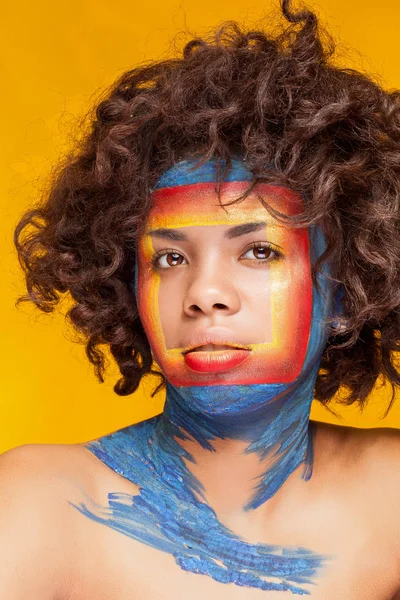 Afro-Amerikaanse vrouw met vierkant op gezicht op gele achtergrond — Stockfoto