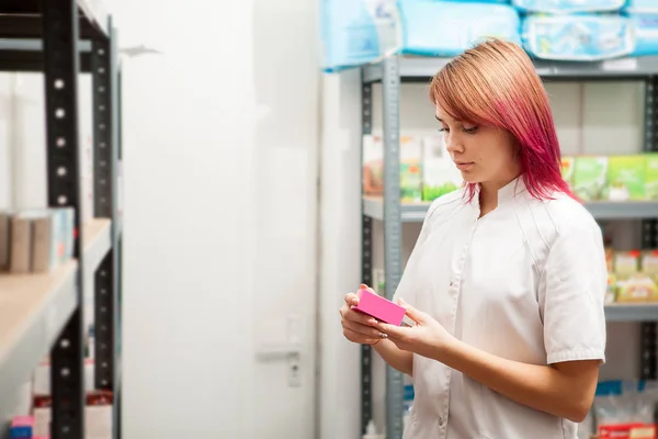 Farmacéutico en almacén mirando la caja de pastillas — Foto de Stock