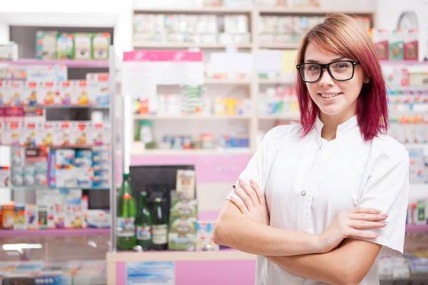 Young pharmacist in glasses inside a pharmacy — Stock Photo, Image