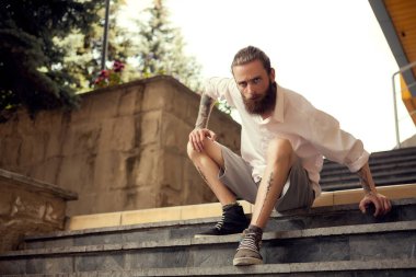 Beardead dövmeli serin sokak merdivenlerde oturan adam arıyorum