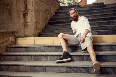Serin seyir hipster merdivenlerde sokakta oturan