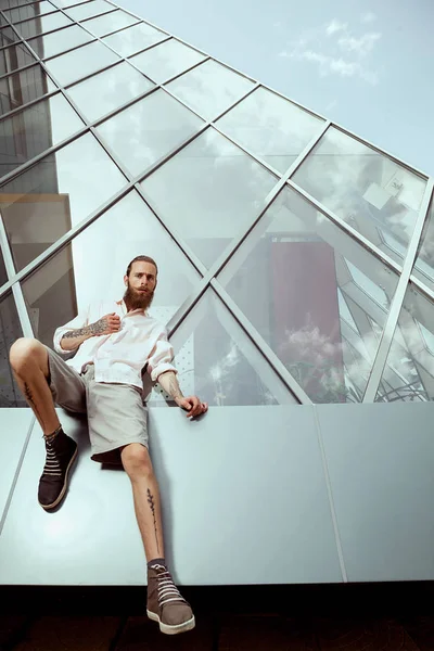 Hipster mit langem Bart und Tätowierungen vor Bürogebäude — Stockfoto