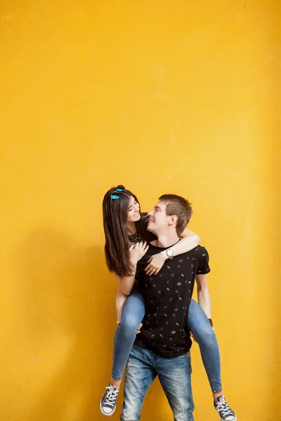 Feliz rindo adolescentes na parede amarela — Fotografia de Stock