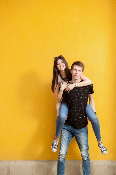 Lachendes Teenie-Paar an gelber Wand — Stockfoto
