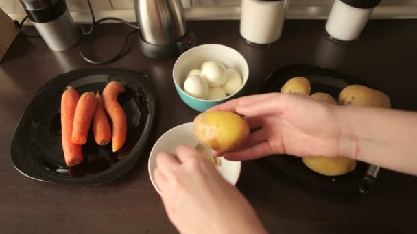 Cleaning boiled potatoes for dinner — Stock Video
