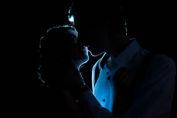 Silhueta de casal amoroso com uma luz azul atrás — Fotografia de Stock