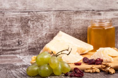 Peynir, bal ve üzüm ahşap arka plan üzerinde