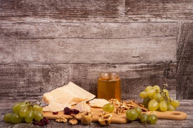 Peynir, bal, üzüm ve fındık ahşap backgr üzerinde farklı tip