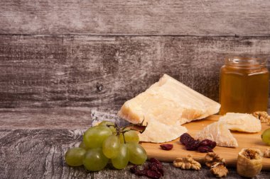 Peynir, bal, üzüm ve fındık ahşap backgr üzerinde farklı tip
