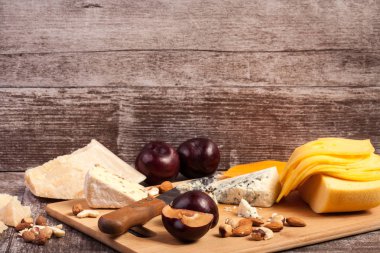 Peynir, fındık ve ahşap arka plan üzerinde meyve