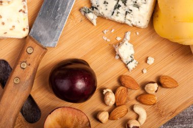 Peynir, fındık ve ahşap arka plan üzerinde meyve