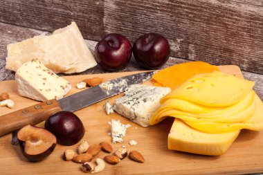 Fındık, peynir ve meyve ahşap arka plan üzerinde