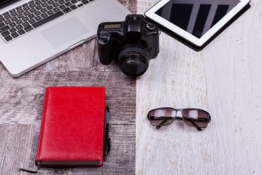 Kamera, dizüstü bilgisayar, yazılı defter ve sunglasse en iyi fotoğrafı üzerinde