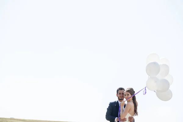 Feliz casal acabado de casar com balões na mão — Fotografia de Stock