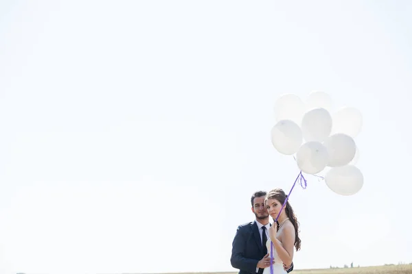 Feliz casal acabado de casar com balões na mão — Fotografia de Stock