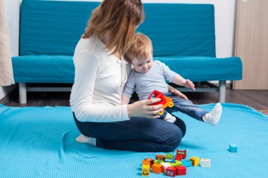 Anne ve oğlu yere oyuncaklar ile oynama