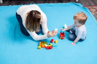 Mutlu bebek çocuk annesinin yanında oyuncaklar ile oynama