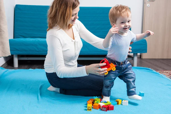 Матері та її сина, граючи з іграшками, на поверсі — стокове фото