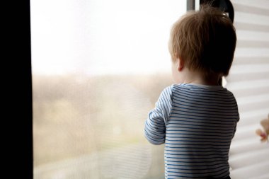 Sevimli küçük çocuk pencereden bakıyor