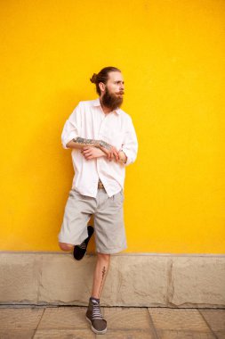 Çekici bir sakallı dövmeli adam sarı duvar
