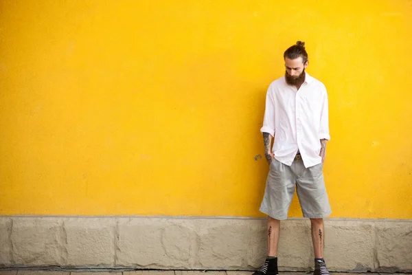 Cool tatoué hipster barbu sur mur jaune — Photo