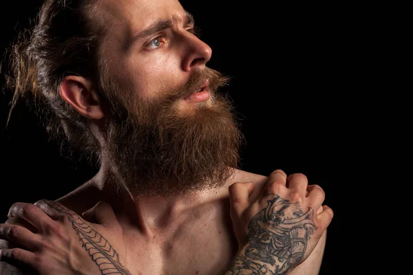 Portrait of tattooed bearded hipster guy on black background — Stock Photo, Image
