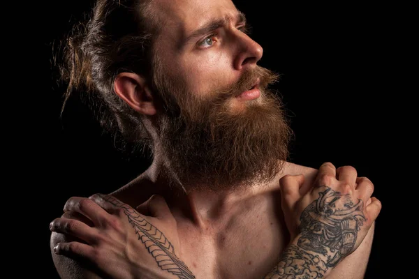Portrait of tattooed bearded hipster guy on black background — Stock Photo, Image