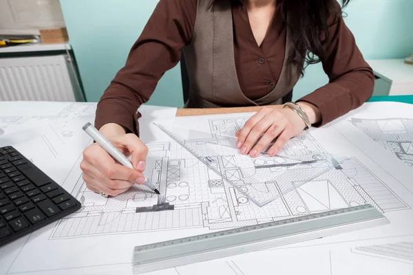 Arquitecta mujer en su mesa trabajando en planos —  Fotos de Stock