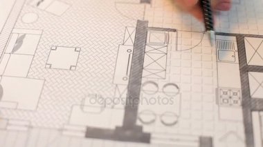 Onun masasında planları üzerinde çalışan kadın mimar