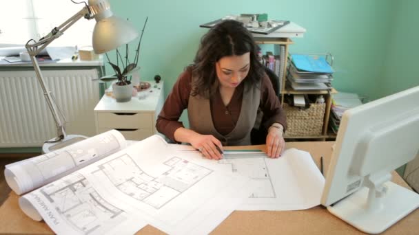 Архітектор працює з кресленнями в її офісі — стокове відео