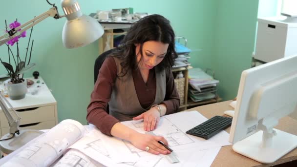 Успешная деловая женщина в своем офисе работает над чертежами — стоковое видео