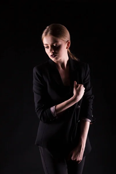 Woman in suit on black background