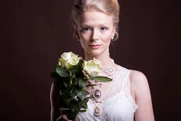 Gorgeous blonde woman in victorian dress with roses in hands — Stock Photo, Image